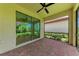 Covered patio features brick flooring, ceiling fan, and sliding glass doors to a garden view at 257 Teramo Way, Nokomis, FL 34275