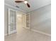 Bright empty room featuring wood floors, ceiling fan, and glass doors leading to another room at 257 Teramo Way, Nokomis, FL 34275