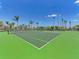 Well-maintained tennis court on sunny day with vibrant green surface, showcasing an active lifestyle amenity at 257 Teramo Way, Nokomis, FL 34275