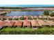 A high aerial view of homes with red roofs along a lakefront community and fountain at 260 Soliera St, Nokomis, FL 34275