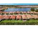 An aerial view showcasing the houses near a lake with a fountain surrounded by lush greenery at 260 Soliera St, Nokomis, FL 34275