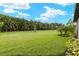 Well-manicured backyard featuring a lush green lawn and mature trees for privacy at 260 Soliera St, Nokomis, FL 34275