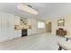 Home bar area with custom cabinetry, a wine refrigerator, tiled flooring, and a stylish chandelier at 2718 Orchid Oaks Dr # C-202, Sarasota, FL 34239