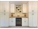 Home bar area featuring a wine refrigerator, custom cabinetry, and stylish decor at 2718 Orchid Oaks Dr # C-202, Sarasota, FL 34239