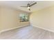 Bedroom features tile flooring, ceiling fan, and a large window at 2718 Orchid Oaks Dr # C-202, Sarasota, FL 34239