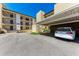 Exterior view of the condo with covered parking and neatly manicured landscaping at 2718 Orchid Oaks Dr # C-202, Sarasota, FL 34239