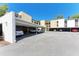 View of the condo complex with covered parking showing multiple parking spots with cars at 2718 Orchid Oaks Dr # C-202, Sarasota, FL 34239