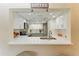 Kitchen with stainless steel appliances, white cabinets, stylish countertops, and open view to the dining area at 2718 Orchid Oaks Dr # C-202, Sarasota, FL 34239