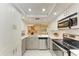 Bright kitchen featuring white cabinetry, stainless steel appliances, and modern countertops at 2718 Orchid Oaks Dr # C-202, Sarasota, FL 34239