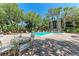 Community pool surrounded by lush greenery, palm trees, and lounge chairs at 2718 Orchid Oaks Dr # C-202, Sarasota, FL 34239