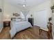 Comfortable bedroom with a soft blue bedspread, hardwood floors, and a window view at 29704 Niagara Court, Englewood, FL 34223