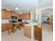 Well-lit kitchen with light wood cabinets, center island, and open access to the living area at 29704 Niagara Court, Englewood, FL 34223