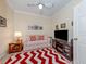 Inviting living room featuring a striped couch, bright rug, and entertainment center at 29704 Niagara Court, Englewood, FL 34223