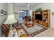 Comfortable living room with tile flooring, entertainment center, and sliding glass doors to lanai at 29704 Niagara Court, Englewood, FL 34223