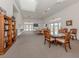Bright lounge area with tables, chairs, and a bookcase, with doors to the pool area at 29704 Niagara Court, Englewood, FL 34223