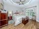 Charming main bedroom with hardwood floors, floral bedding, and a tray ceiling at 29704 Niagara Court, Englewood, FL 34223