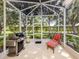 Enclosed patio with grill, chair, and spacious area, perfect for relaxation and outdoor enjoyment at 29704 Niagara Court, Englewood, FL 34223