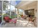 Covered and screened patio with comfortable lounge chair and seating, ideal for relaxation at 29704 Niagara Court, Englewood, FL 34223