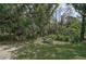 Backyard with grass area, mature trees, and picnic table at 3199 Elkrem Ave, North Port, FL 34286