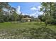 Large backyard with a screened-in porch and open lawn, ideal for outdoor activities at 3199 Elkrem Ave, North Port, FL 34286