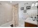 Bathroom features shower-tub combo, single sink vanity, tile flooring, and neutral paint at 3199 Elkrem Ave, North Port, FL 34286