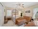 Bedroom features four-poster bed, ceiling fan, light-yellow walls, and neutral carpeting at 3199 Elkrem Ave, North Port, FL 34286