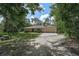 Charming single-story home surrounded by mature trees and featuring a long, paved driveway at 3199 Elkrem Ave, North Port, FL 34286