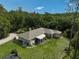 Rear exterior showcasing a well-maintained yard, screened patio and mature trees at 3199 Elkrem Ave, North Port, FL 34286