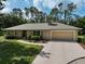 Charming single-story home with a long driveway, two-car garage, and lovely landscaping at 3199 Elkrem Ave, North Port, FL 34286