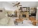 Open-concept living room with stone fireplace, tiled floors, and views into dining area through glass doors at 3199 Elkrem Ave, North Port, FL 34286