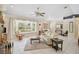 Bright and airy living room with tile floors, window seat, large window and a cozy cream colored sofa at 3199 Elkrem Ave, North Port, FL 34286