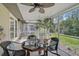 Screened porch with ceiling fan, table, chairs, and view of backyard at 3199 Elkrem Ave, North Port, FL 34286