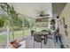 Screened porch with ceiling fan, table, and chairs with backyard view at 3199 Elkrem Ave, North Port, FL 34286