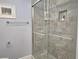 Bathroom shower with gray tiling and glass door at 333 The Esplanade N # 102, Venice, FL 34285