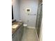 Bathroom featuring gray tile flooring, framed artwork, a shower, and a gray granite topped vanity at 333 The Esplanade N # 102, Venice, FL 34285