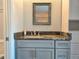 Charming bathroom with grey cabinetry, granite countertops, and a framed mirror at 333 The Esplanade N # 102, Venice, FL 34285