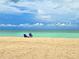 Beach scene with blue chairs, and tranquil turquoise ocean view at 333 The Esplanade N # 102, Venice, FL 34285