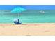 Relaxing beach scene featuring an umbrella, chair, and ocean views at 333 The Esplanade N # 102, Venice, FL 34285