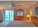 Bright bedroom with wooden furniture, ceiling fan, and sliding doors at 333 The Esplanade N # 102, Venice, FL 34285