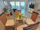Bright dining area features a glass table with wicker chairs, and sliding glass doors that look out onto the beach at 333 The Esplanade N # 102, Venice, FL 34285