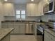 Bright kitchen featuring gray cabinets, granite counters, and stainless steel appliances at 333 The Esplanade N # 102, Venice, FL 34285