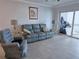 Comfortable living room with gray sofa, chair, tile flooring, and natural light at 333 The Esplanade N # 102, Venice, FL 34285