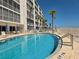 Community pool with beach access, lounge chairs and palm trees on a sunny day at 333 The Esplanade N # 102, Venice, FL 34285