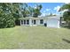 Lush backyard featuring a well-maintained lawn, an exterior view of the sunroom, and a storage shed at 3340 Webber St, Sarasota, FL 34239