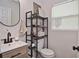 Well-lit half bathroom featuring a modern vanity, toilet, and decorative shelving for storage at 3340 Webber St, Sarasota, FL 34239