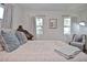 Bright bedroom with natural light, featuring neutral bedding, a vintage desk, and comfortable seating at 3340 Webber St, Sarasota, FL 34239