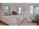 Bright bedroom with natural light, featuring neutral bedding, a vintage desk, and comfortable seating at 3340 Webber St, Sarasota, FL 34239