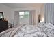 Bedroom features a patterned duvet, neutral curtains, modern furniture, and ample natural light from the window at 3340 Webber St, Sarasota, FL 34239