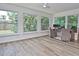 Bright sunroom featuring large windows with wooded backyard views at 3340 Webber St, Sarasota, FL 34239