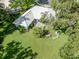 A sprawling backyard offers lush green space, mature trees, and a charming seating area at 337 Meadow Beauty Ct, Venice, FL 34293